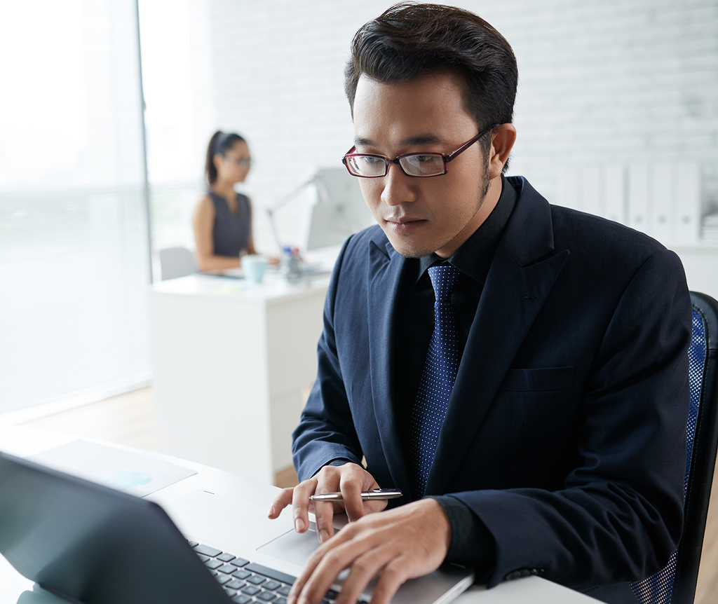 Asian businessman working on a laptop in a coworking space